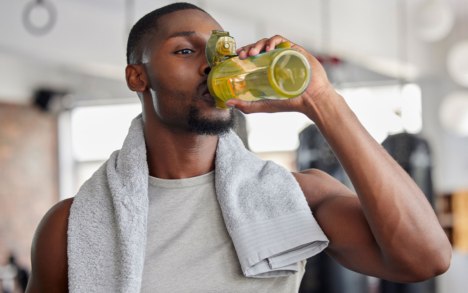 Photo of man drinking from a water bottle for a blog about healthy hydration during the holidays