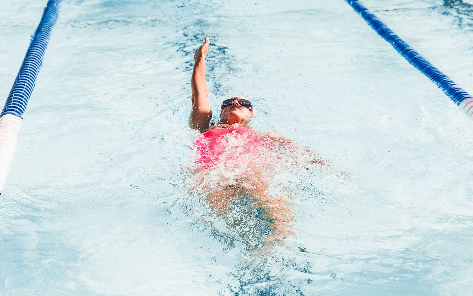 person doing backstroke in swell goleta pool