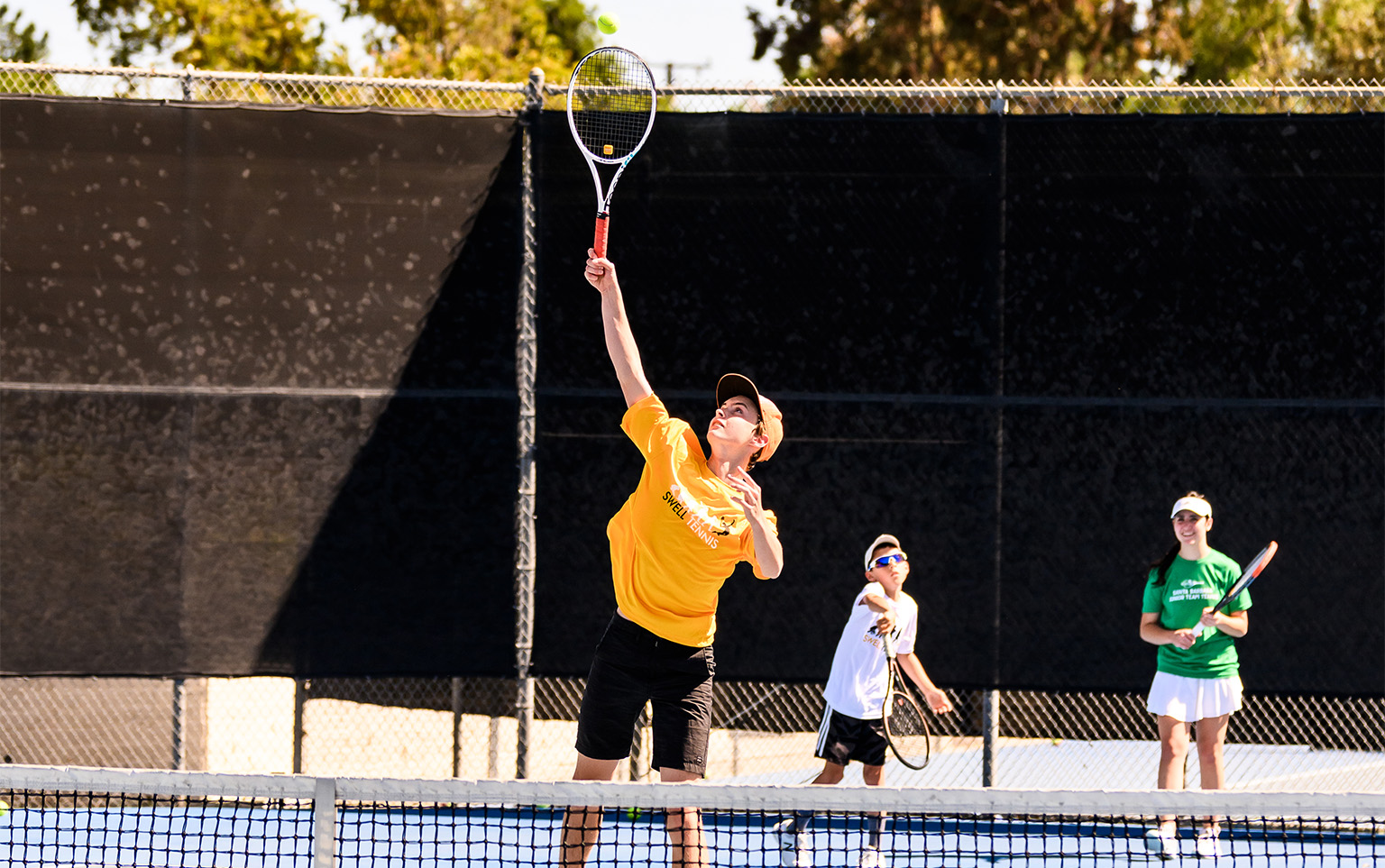 kids playing tennis on a court for a blog about tennis classes for kids