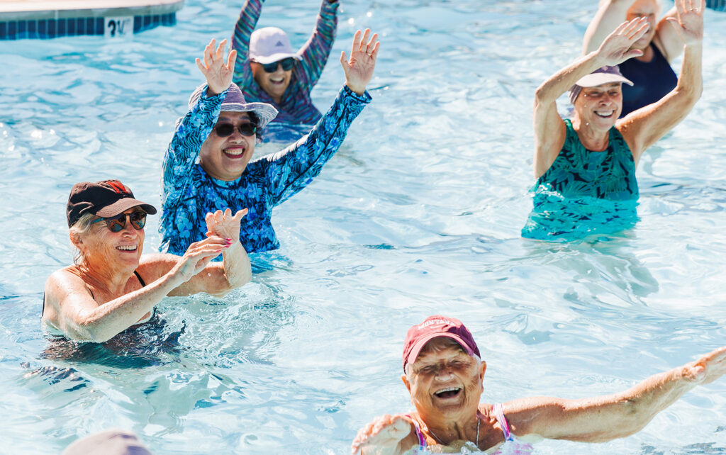 elderly group of people in pool for an aquatic class smiling for a blog about the best ways to stay active outdoors