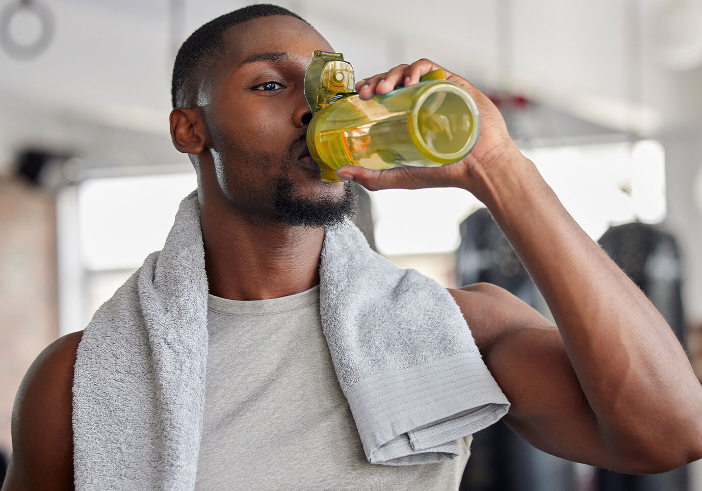 Photo of man drinking from a water bottle for a blog about healthy hydration during the holidays