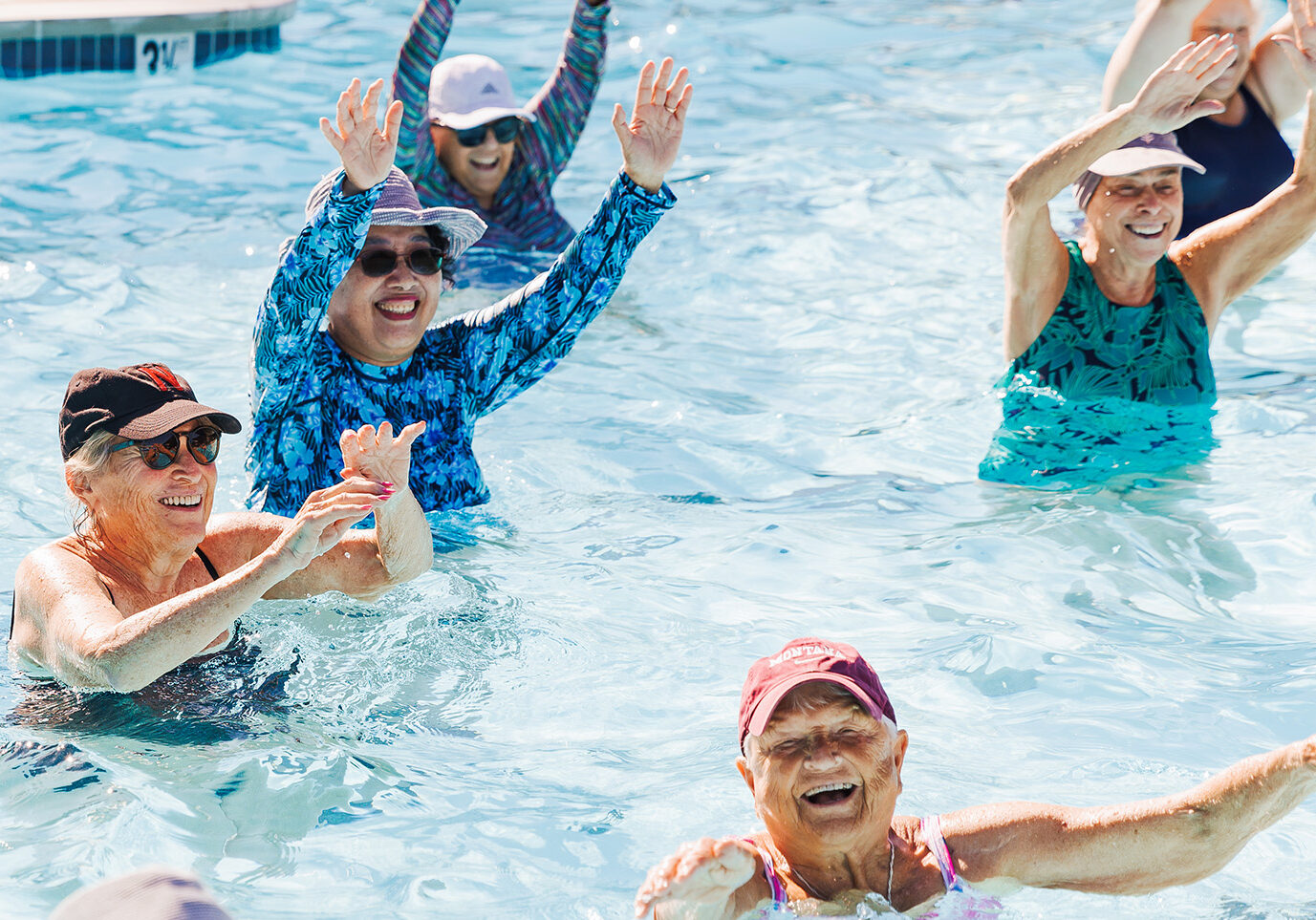 elderly group of people in pool for an aquatic class smiling for a blog about the best ways to stay active outdoors