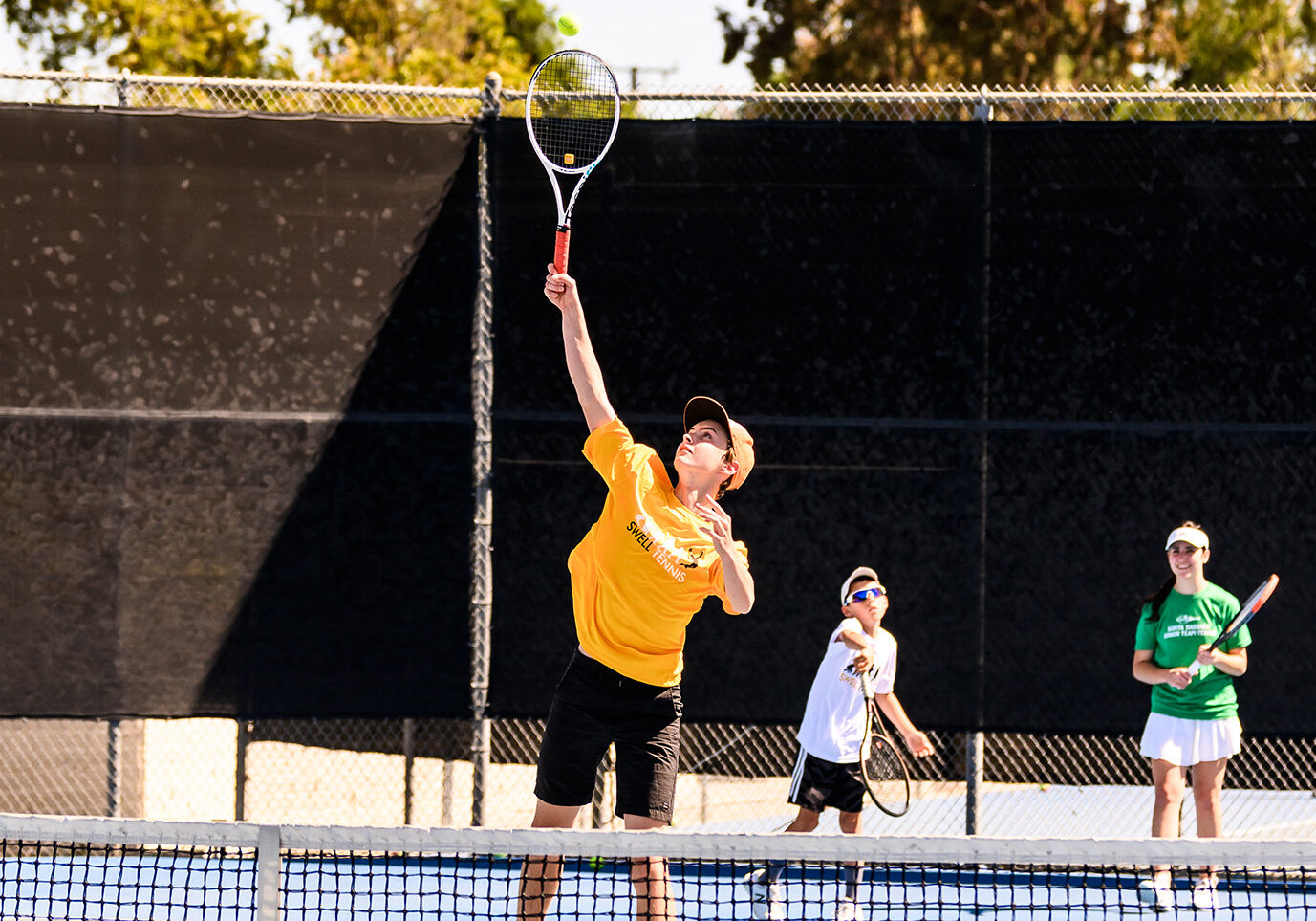 kids playing tennis on a court for a blog about tennis classes for kids