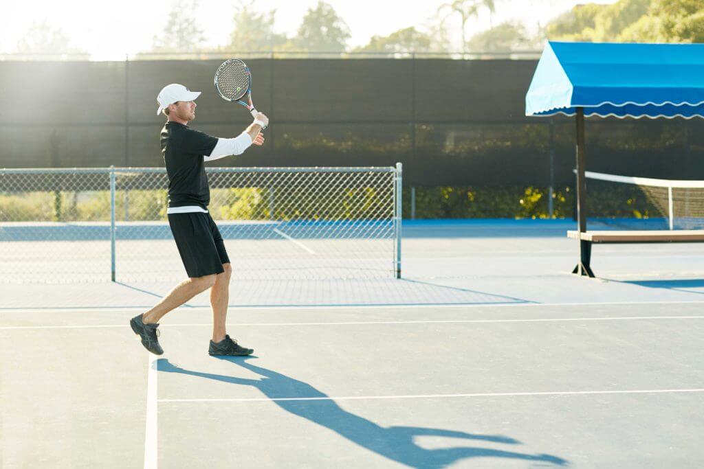 Male tennis instructor playing tennis