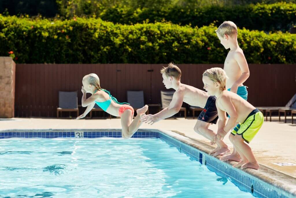 Kids jumping onto a pool