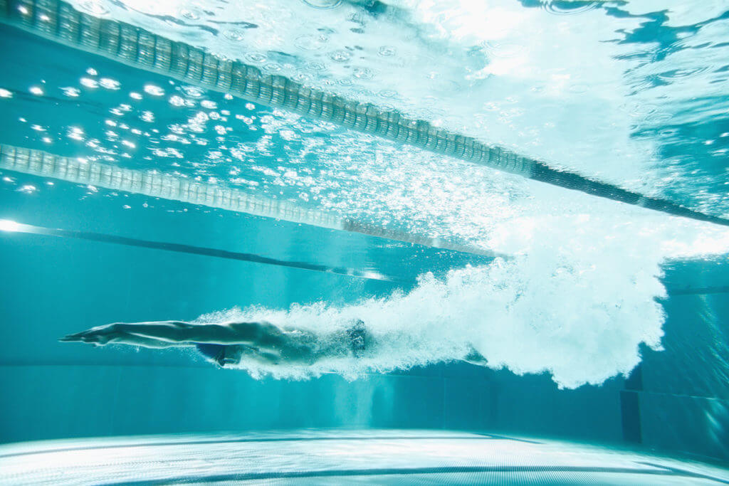 Swimmer underwater after a dive jump